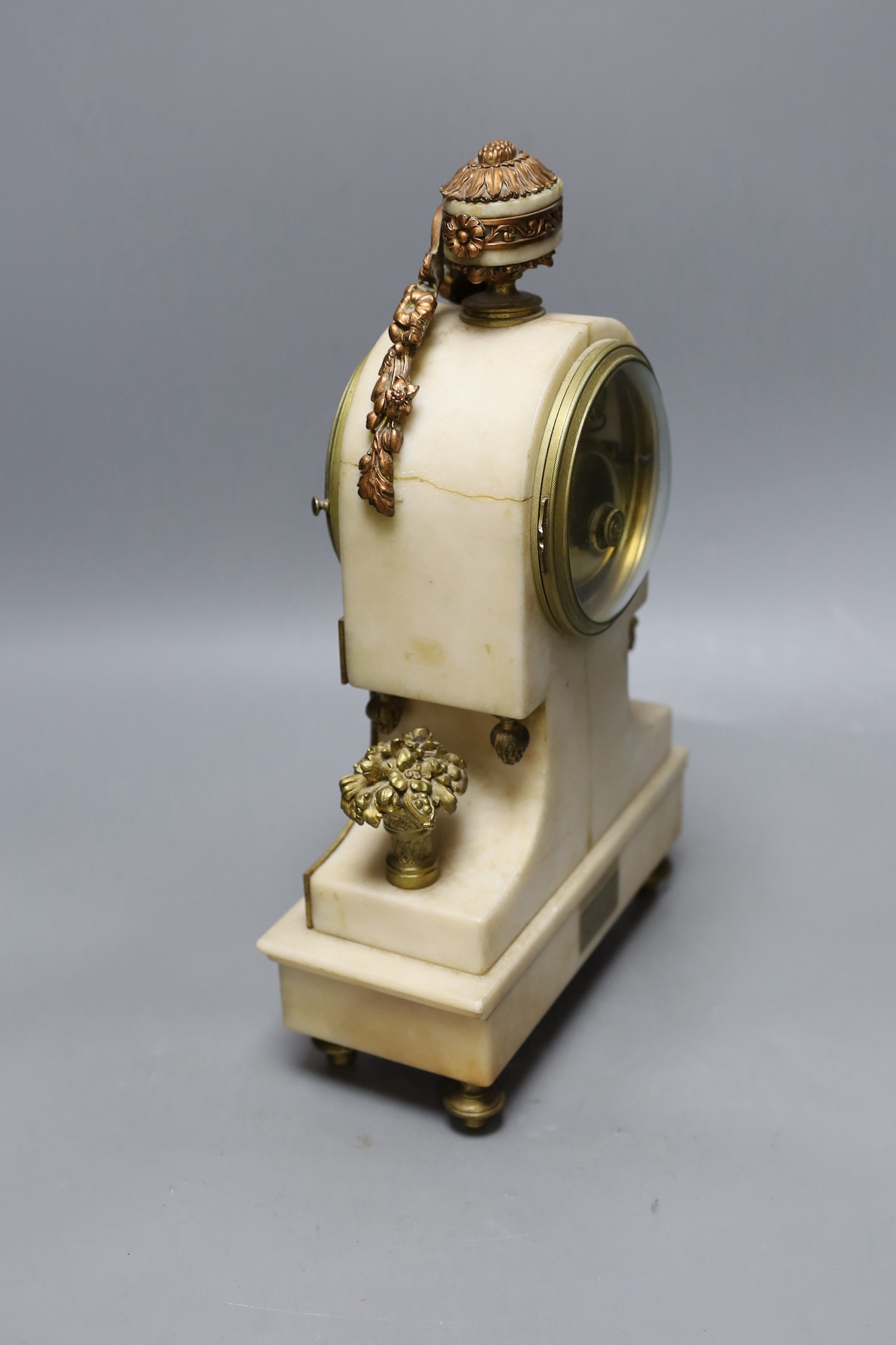 A 19th century French alabaster and phosphur bronze mounted mantel clock with a painted demi lune inset. 33cm tall